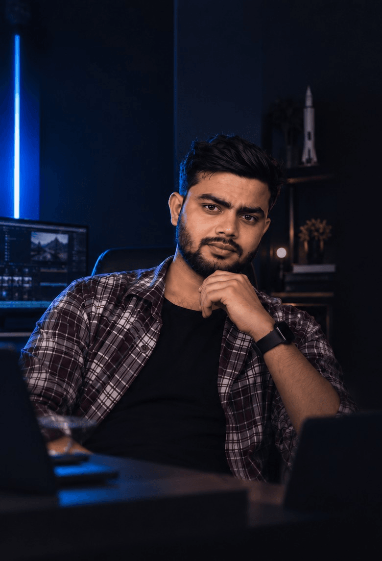 Anand Pandey at his desk in a dark studio lit by a blue neon light, beside an editing monitor